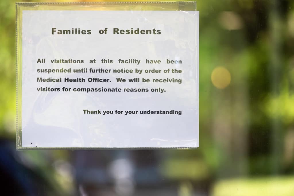 No visiting notice to families of residents posted on front door of long term care facility.  Vancouver, British Columbia, Canada.