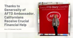 AFTD Ambassador Terry Walter, of California, smiles in front of a red AFTD banner that says Every FTD Story Counts.